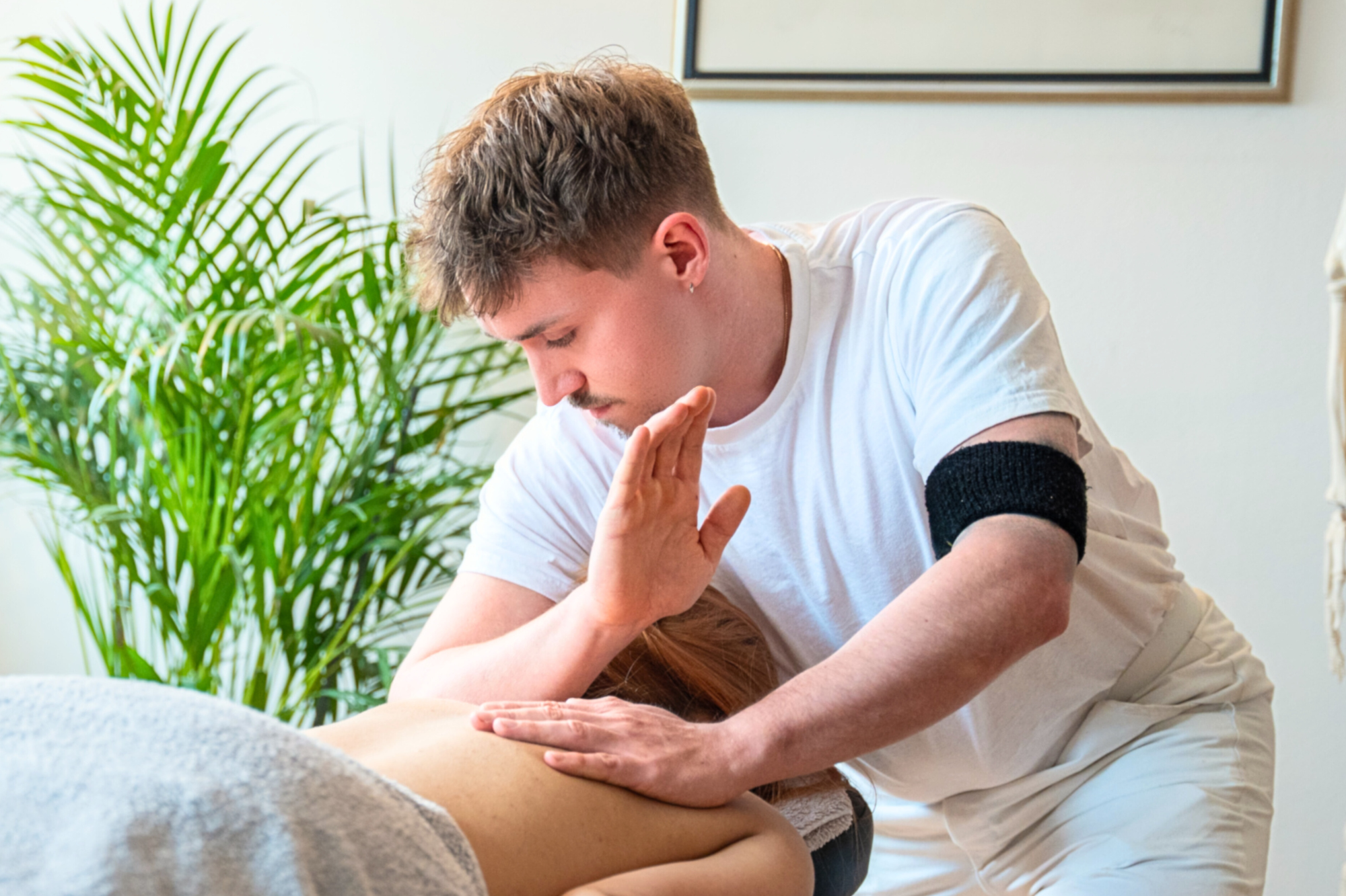 Heilmasseur Domenic Hacker bei der Arbeit während einer Behandlung in Wien